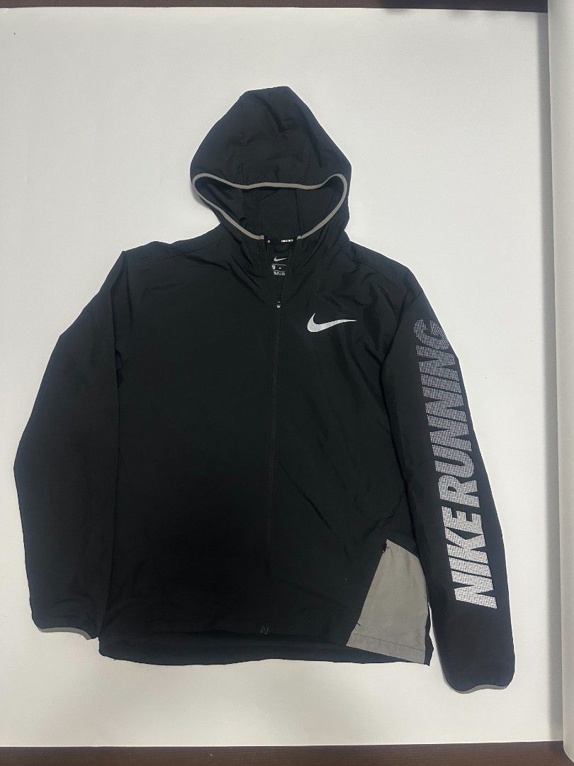 Nike Running Hooded Jacket Black Men's Size M (Category: Coats, Jackets and Outerwear) located in Manila. Submitted by rodeltzy (Listing ID 1469825127, Image 1). Description: - Brand: Nike - Item: Running Jacket - Color: Black - Size: Medium (Style Code: 933838-010) - Features: Attached hood with drawcord, full zip front - Details: Large reflective Nike swoosh on the back, text on left sleeve, and Nike Running inner collar taping - Origin: Made i