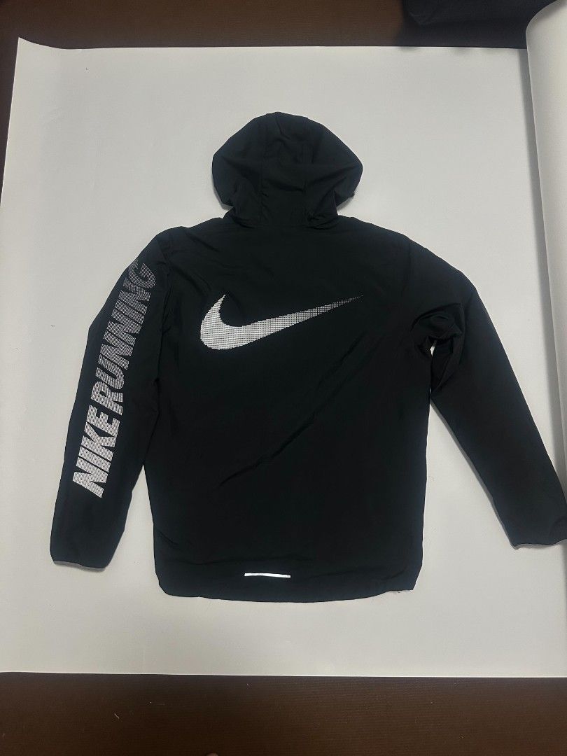 Nike Running Hooded Jacket Black Men's Size M (Category: Coats, Jackets and Outerwear) located in Manila. Submitted by rodeltzy (Listing ID 1469825127, Image 2). Description: - Brand: Nike - Item: Running Jacket - Color: Black - Size: Medium (Style Code: 933838-010) - Features: Attached hood with drawcord, full zip front - Details: Large reflective Nike swoosh on the back, text on left sleeve, and Nike Running inner collar taping - Origin: Made i