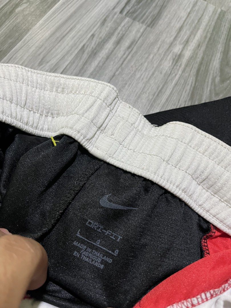 Nike Spell out (Category: Shorts) located in Cavite. Submitted by arespichri90266 (Listing ID 1469785051, Image 3). Description: - Brand: Nike - Style: Dri-FIT Basketball Shorts (Style Code: CV1866-010) - Size: Large - Colorway: Black, red, and white with a distinctive striped front panel - Features: Adjustable drawstring waist, white waistband, and embroidered white Nike swoosh - Material: 100% polyester - Origin: Made in Thailand - Condition: C