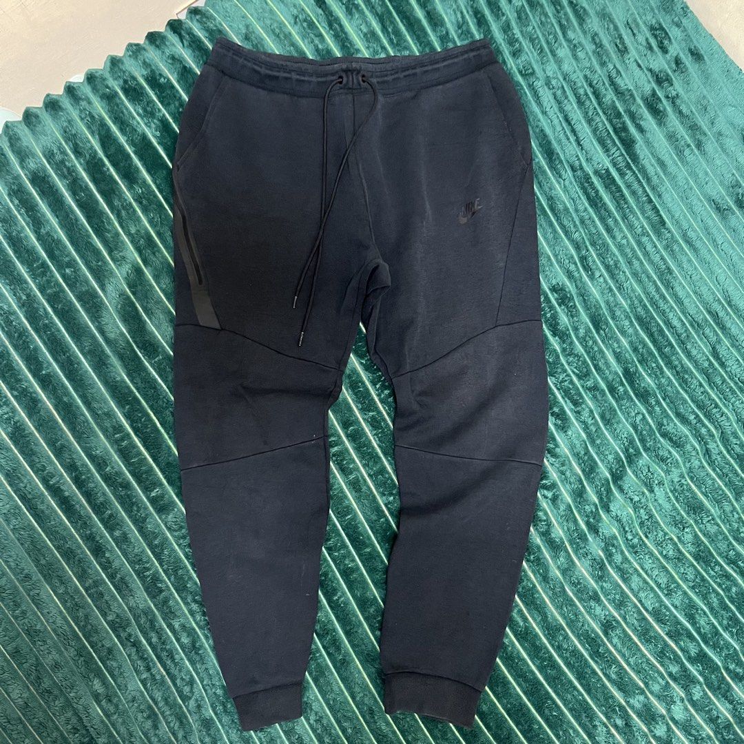 Nike Tech Fleece Joggers Black (Category: Joggers) located in Manila. Submitted by thriftkolngeh (Listing ID 1469934960, Image 1). Description: - Authentic Black Nike Tech Fleece sweatpants - Comfortable regular fit for casual streetwear - Premium cotton and polyester blend fabric - Elastic drawstring waistband for an adjustable fit - Ribbed cuffs to lock in warmth and showcase sneakers - Signature zippered pocket on the right leg - Made in Cambo