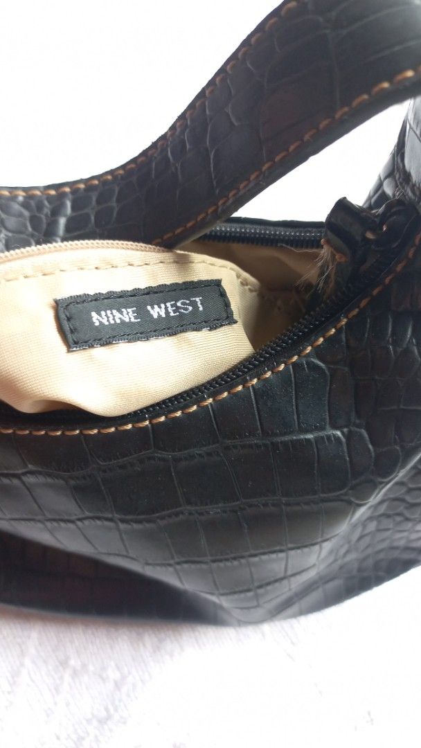 Nine West Black Crocodile Print Shoulder Bag (Category: Shoulder Bags) located in Rizal. Submitted by mayra74 (Listing ID 1469766416, Image 3). Description: - Brand: Nine West - Style: Black mini shoulder/kili bag with single strap - Material: Crocodile embossed faux leather with brown contrast stitching - Closure: Secure top zipper - Interior: Beige fabric lining with one zipper pocket - Condition: Clean overall, practical for daily use.