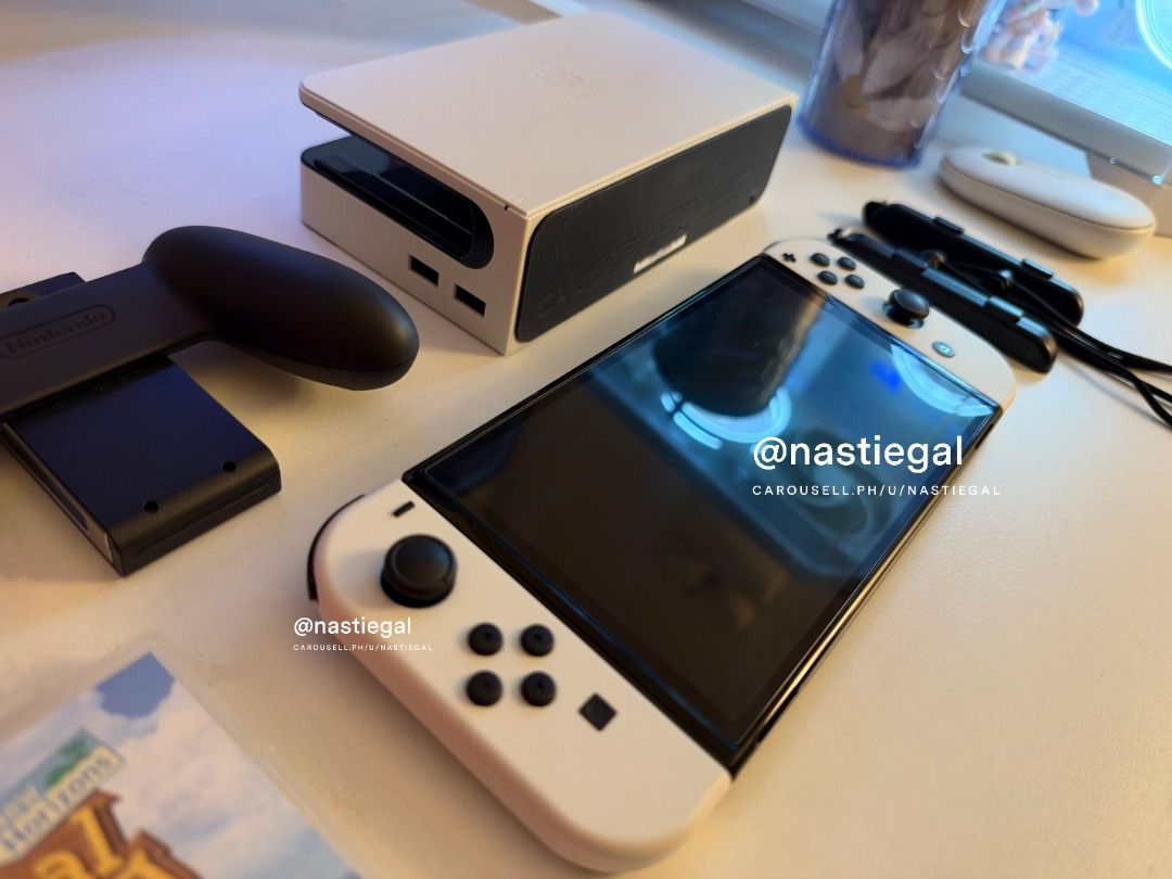 Nintendo Switch OLED White + Animal Crossing + Amiibos (Category: Nintendo) located in Las Pinas. Submitted by nastiegal (Listing ID 1469884351, Image 2). Description: - Nintendo Switch OLED Console (White) in pristine condition - Lady owned - With tempered glass since day 1 - Clean screen and hardware with zero issues - Complete with original dock, Joy-Con controllers, straps, grip, hdmi, charger and cord - Includes original box and Animal Cross