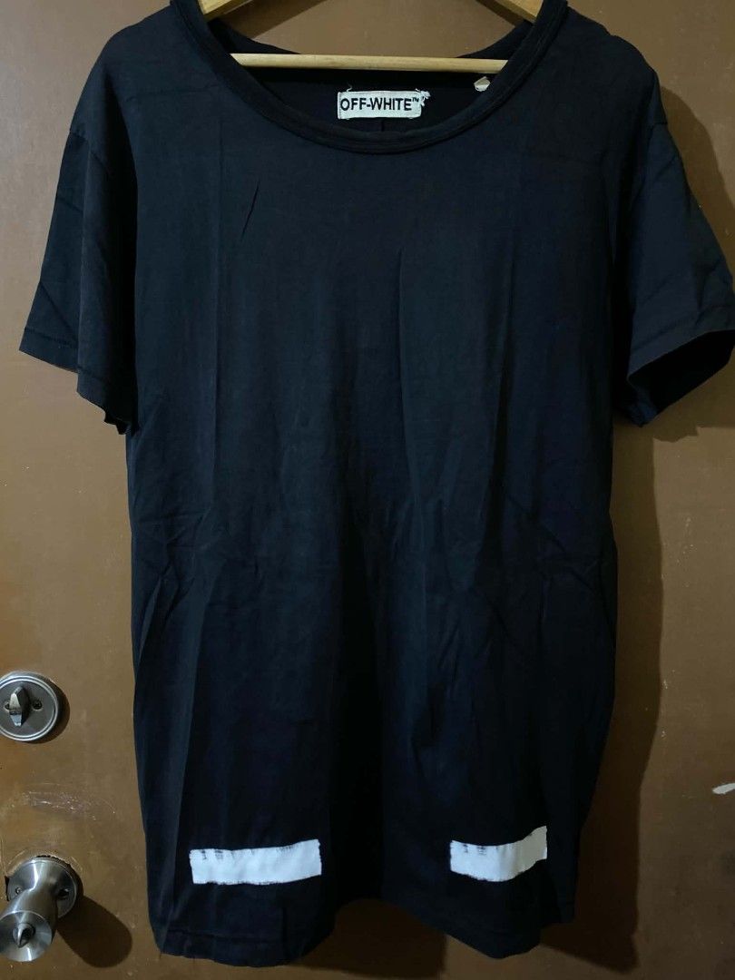 Off-White Black T-Shirt Size L (Category: Shirts) located in Taguig. Submitted by cabugchear34421 (Listing ID 1469879056, Image 1). Description: - Off-White c/o Virgil Abloh - Black - Large (Made in Portugal) - 100% cotton - Iconic diagonal stripes on the back with 'WHITE' text and small horizontal stripes near the front hem ISSUE: Crack prints Bacon neckline (slight).