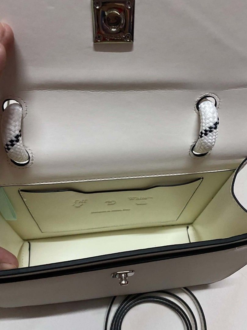 Off-White White Leather Burrow Bag with Rope Handle (Category: Shoulder Bags) located in Manila. Submitted by gutierrez23265 (Listing ID 1469784481, Image 2). Description: Off-White leather handbag in clean white. Distinctive rope top handle with knotted details. Silver tone arrow closure on the front flap. Structured rectangular silhouette with clean black edge painting. Interior slip pocket with subtle debossed logo branding. Removable thin lea