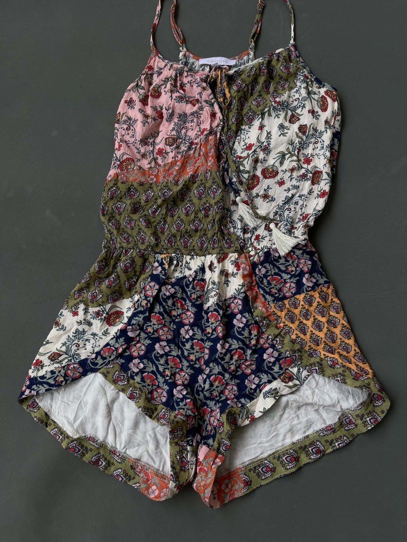 Olivaceous Floral Patchwork Spaghetti Strap Romper Size S (Category: Rompers) located in Baguio. Submitted by lovelaira (Listing ID 1469852811, Image 3). Description: Olivaceous brand, size S. Colorful floral patchwork design with mixed patterns in pink, green, white, and navy blue. Spaghetti straps with adjustable gold-tone sliders. Scoop neckline featuring tassel drawstring ties. Lightweight fabric, cinched elastic waist, flowy shorts construct