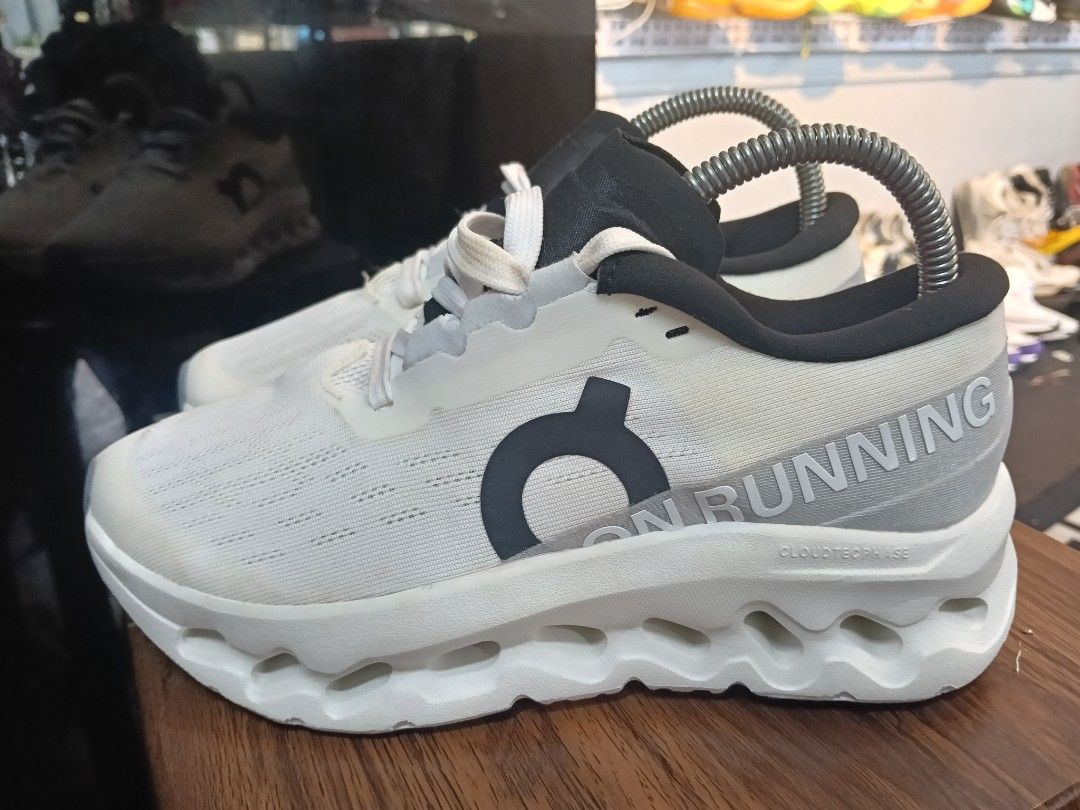 On Running Cloudmonster White Black Running Shoes (Category: Sneakers) located in Manila. Submitted by mariarezap86451 (Listing ID 1469784818, Image 1). Description: - Brand/Model: On Running Cloudmonster - Colorway: White and Black with vibrant orange insoles - Design: Chunky cushioned sole with cutout details and bold branding on the side and heel - Condition: Excellent pre-loved/new (as applicable) - Note: Metal shoe trees shown in photos are 