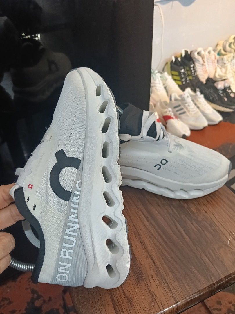 On Running Cloudmonster White Black Running Shoes (Category: Sneakers) located in Manila. Submitted by mariarezap86451 (Listing ID 1469784818, Image 3). Description: - Brand/Model: On Running Cloudmonster - Colorway: White and Black with vibrant orange insoles - Design: Chunky cushioned sole with cutout details and bold branding on the side and heel - Condition: Excellent pre-loved/new (as applicable) - Note: Metal shoe trees shown in photos are 