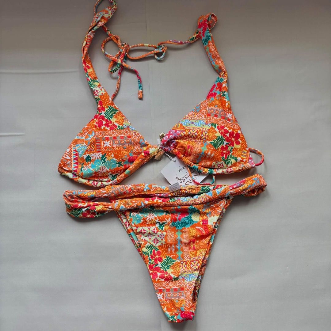 Orange Floral Print Halter Bikini Set (Category: Bikinis & Swimsuits) located in Taguig. Submitted by imeverywhereimsellahhhh (Listing ID 1469821277, Image 1). Description: - Brand new with tags still attached - Bright orange color with multi-color floral and geometric patterns - Halter neck top with adjustable string ties - Matching bottoms featuring a stylish folded waistband - Perfect statement piece for the beach or pool parties.