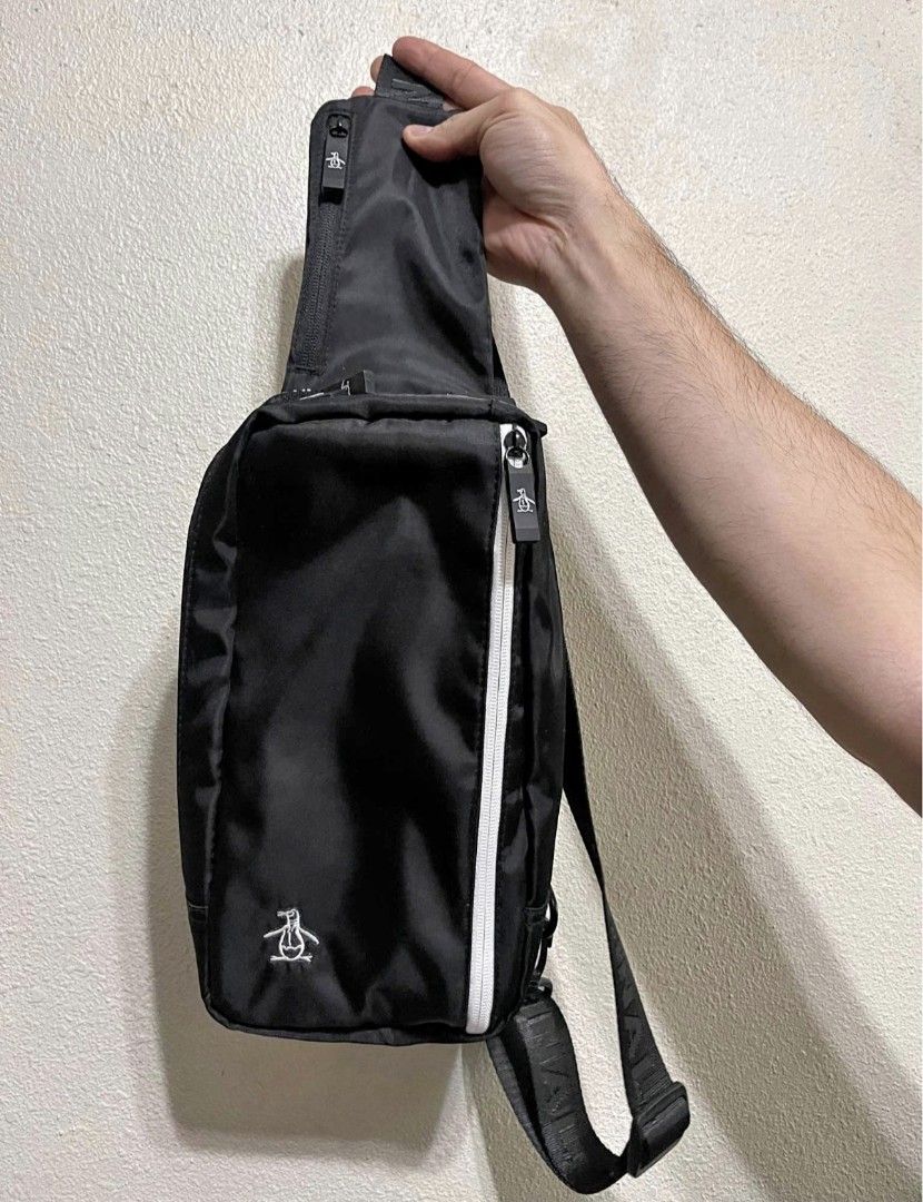 Original Penguin Black Crossbody Sling Bag (Category: Sling Bags) located in Malabon City. Submitted by neon.neon2 (Listing ID 1469908095, Image 1). Description: - Authentic Original Penguin black sling bag - Durable nylon material with branded text straps and zipper pulls - Front vertical white zipper compartment for quick access - Spacious main zip storage compartment - Adjustable strap for shoulder or crossbody wear - Clean condition with mini