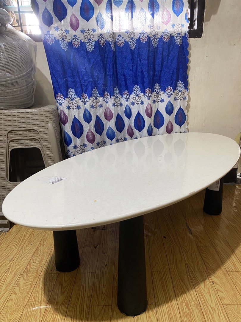 Oval Marble-effect Center Table (Category: Tables & Sets) located in Quezon. Submitted by odd.theprelovedhub (Listing ID 1469800052, Image 2). Description: • Tabletop: White/cream artificial marble or marble-effect finish with an oval shape. • Base: Black cylindrical/sculptural support legs. • Typical Dimensions: Length of 120 cm, width of 60 cm, and standard dining height (around 45 cm) .