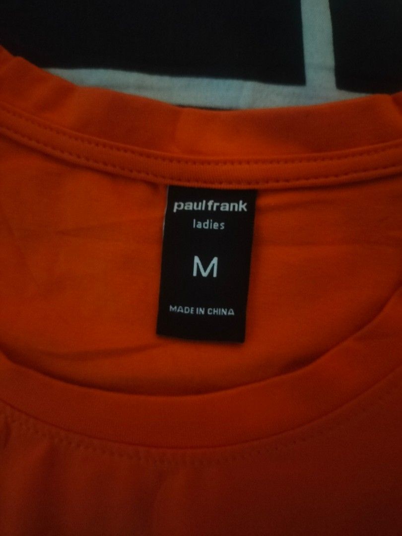 Paul Frank Orange T-shirt (Category: Shirts) located in Manila. Submitted by fareastthrift (Listing ID 1469847407, Image 2). Description: - Brand: Paul Frank - Color: Bright Orange - Size: Medium (tag attached) - Design: Julius the monkey graphic with text art - Material: Soft cotton blend - Fit: Short sleeves, crew neck - Condition: Great casual top for everyday wear.