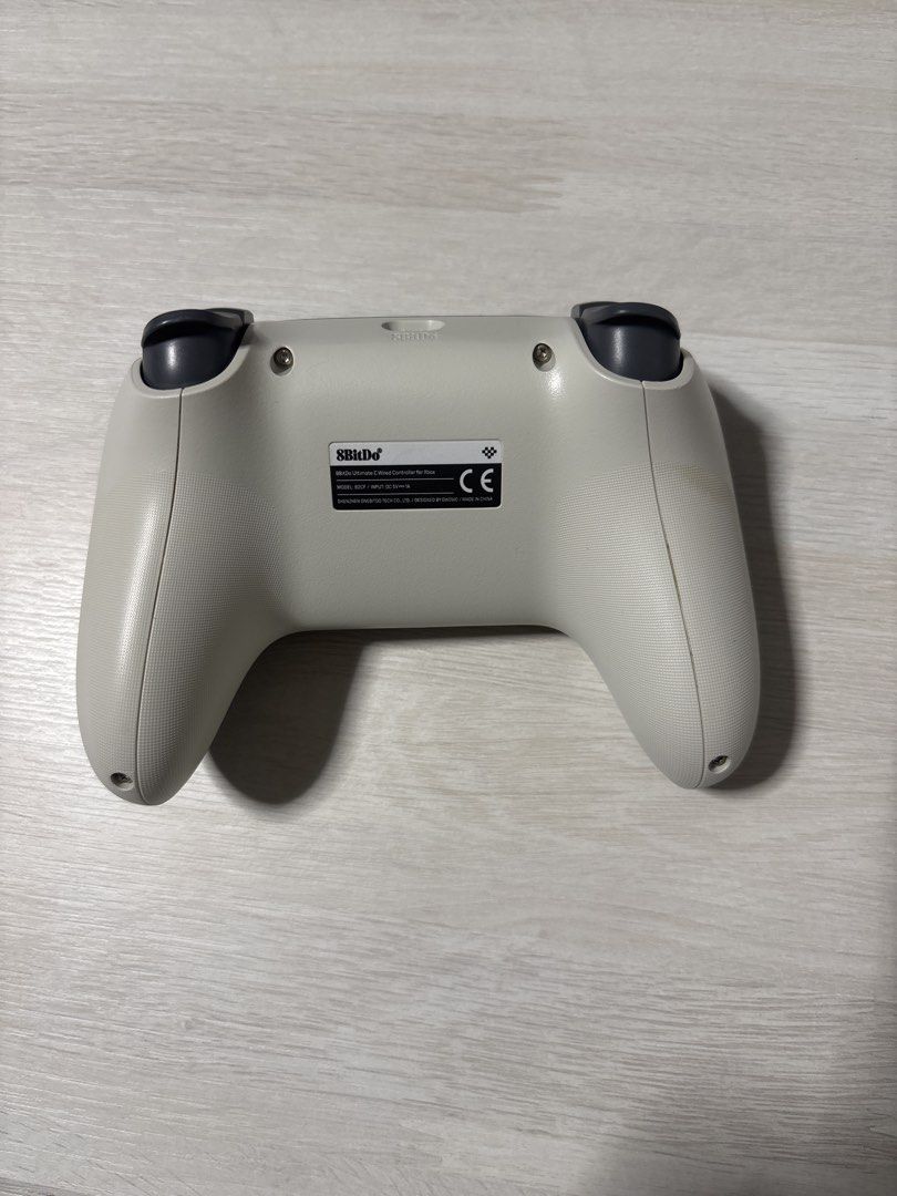 PC/XBOX gaming controller 8BitDo Ultimate C Wired Controller (Category: Controllers) located in Singapore. Submitted by mrlapras7 (Listing ID 1469892321, Image 3). Description: - Model: 8BitDo Ultimate C Wired Controller - Compatibility: Xbox and PC gaming - Color/Design: Dark grey faceplate, white buttons, and glowing orange accent rings - Condition: Fully functional and clean - Key Features: Textured back grips for comfort, standard layout (d-p