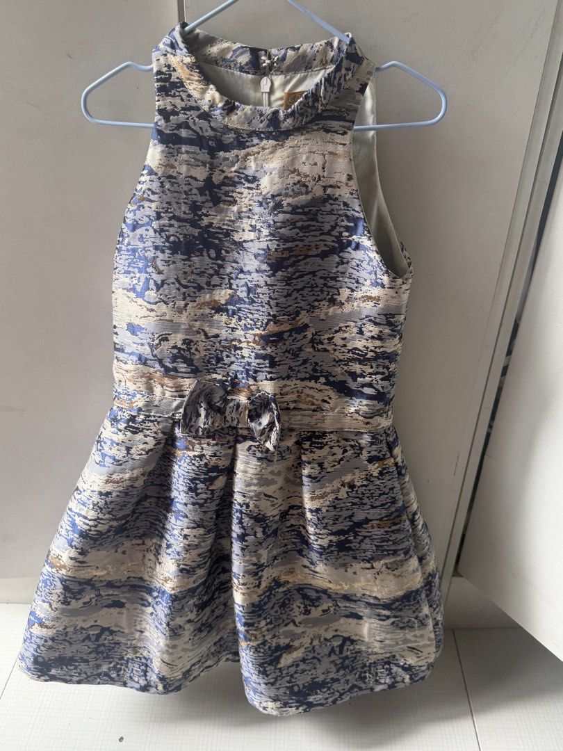 Peppermint Blue Gold Pattern Dress Size 6 (Category: Babies & Kids Fashion) located in Paranaque City. Submitted by npineda13 (Listing ID 1469801255, Image 1). Description: - Brand: Peppermint - Size: 6 - Length: 26.5 inches - Dress only - Preloved but in good condition - Design: Blue and gold abstract pattern - Style: Sleeveless halter neckline with a cute waist bow and structured flared skirt - Closure: Back zipper with hook and eye fastening a