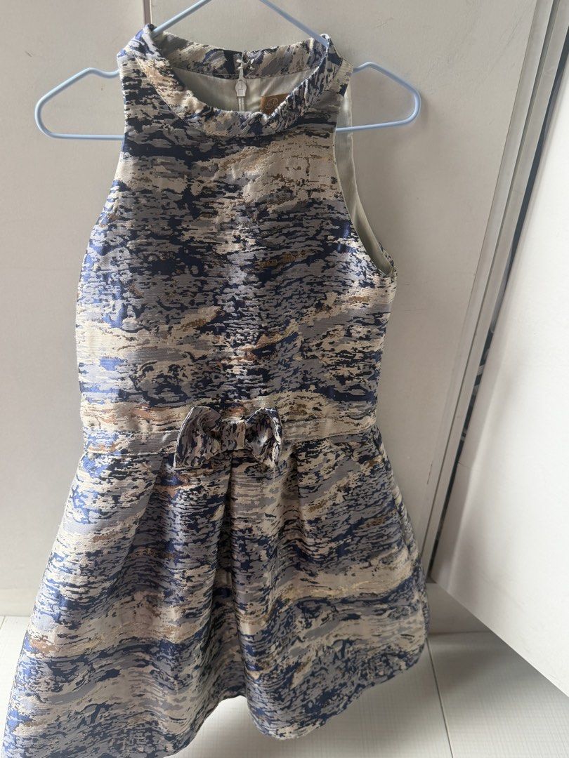 Peppermint Blue Gold Pattern Dress Size 6 (Category: Babies & Kids Fashion) located in Paranaque City. Submitted by npineda13 (Listing ID 1469801255, Image 3). Description: - Brand: Peppermint - Size: 6 - Length: 26.5 inches - Dress only - Preloved but in good condition - Design: Blue and gold abstract pattern - Style: Sleeveless halter neckline with a cute waist bow and structured flared skirt - Closure: Back zipper with hook and eye fastening a