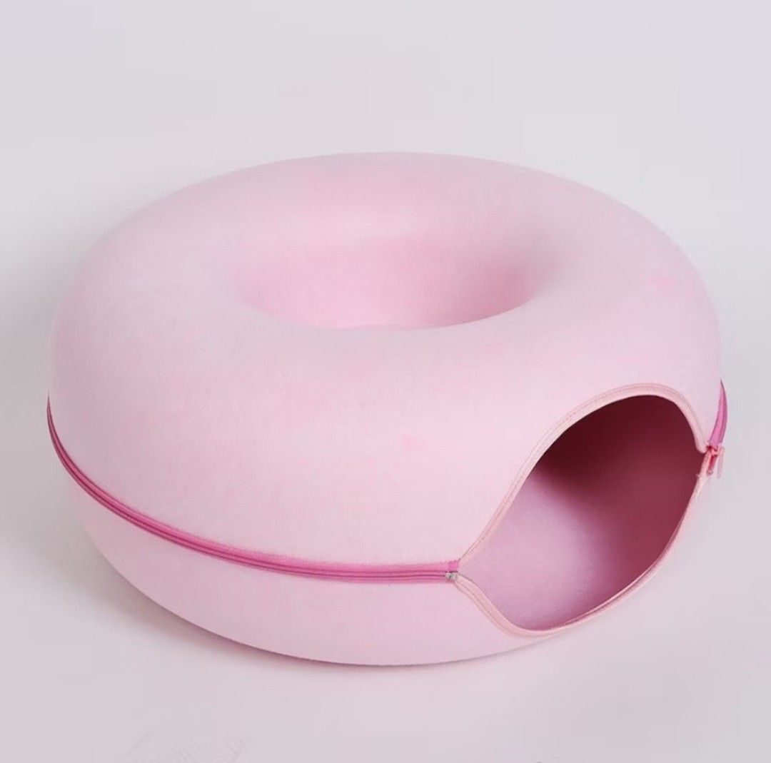 Pink Donut Cat Bed Cave House (Category: Bedding & Towels) located in Cainta. Submitted by ej_emuslan (Listing ID 1469789830, Image 1). Description: - Color: Soft pastel pink - 2-in-1 Design: Enclosed cave tunnel for hiding and round top lounge area for sleeping - Easy to Clean: Zip-apart design makes washing hassle-free - Durable: Sturdy material that maintains its shape well - Perfect for cats and small pets who love cozy spaces.