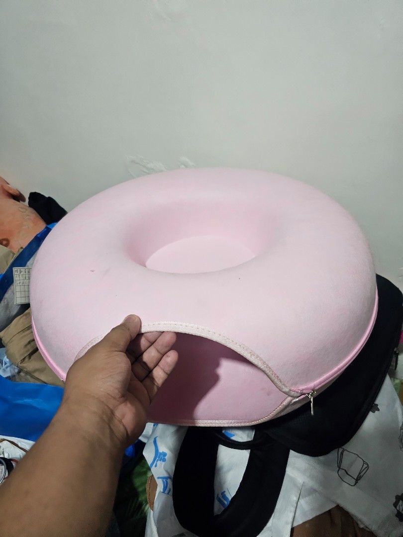 Pink Donut Cat Bed Cave House (Category: Bedding & Towels) located in Cainta. Submitted by ej_emuslan (Listing ID 1469789830, Image 2). Description: - Color: Soft pastel pink - 2-in-1 Design: Enclosed cave tunnel for hiding and round top lounge area for sleeping - Easy to Clean: Zip-apart design makes washing hassle-free - Durable: Sturdy material that maintains its shape well - Perfect for cats and small pets who love cozy spaces.
