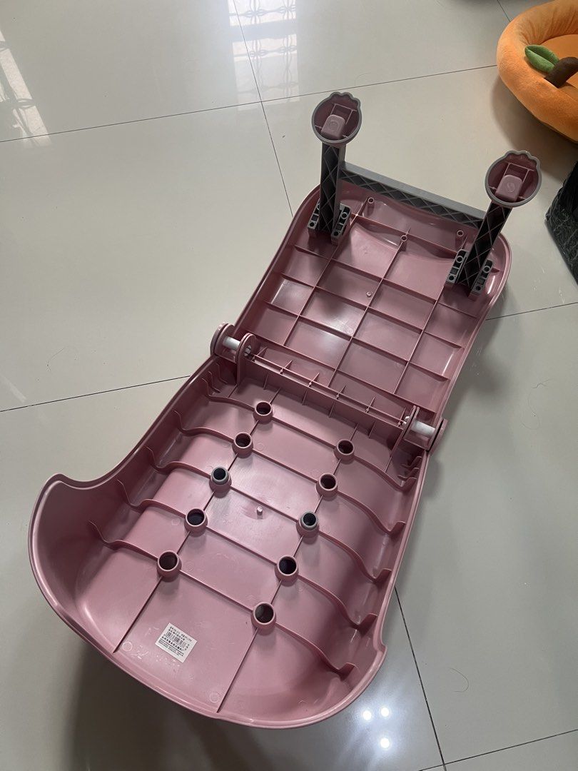 Pink foldable baby bath chair with headrest (Category: Bathtub & Bath Accessories) located in Cainta. Submitted by hunchester (Listing ID 1469895587, Image 2). Description: - Pink foldable shampoo chair designed for kids - Includes a comfortable grey headrest and neck support - Features drainage holes along the middle and bottom sections for easy water flow - Equipped with sturdy grey legs for stability - Folds completely flat for convenient and 