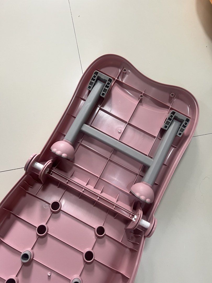 Pink foldable baby bath chair with headrest (Category: Bathtub & Bath Accessories) located in Cainta. Submitted by hunchester (Listing ID 1469895587, Image 3). Description: - Pink foldable shampoo chair designed for kids - Includes a comfortable grey headrest and neck support - Features drainage holes along the middle and bottom sections for easy water flow - Equipped with sturdy grey legs for stability - Folds completely flat for convenient and 