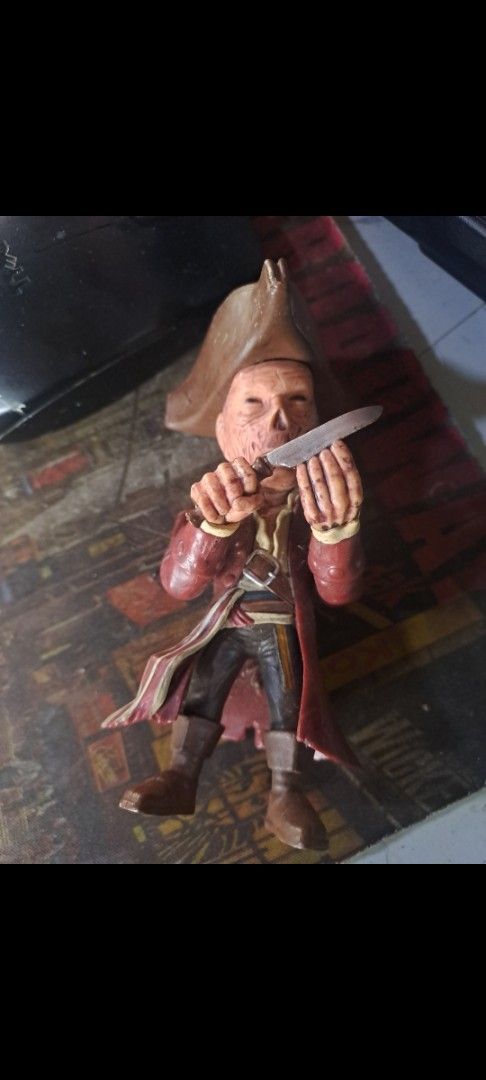 Pirate Skeleton Action Figure with Knife (Category: Figurines & Statues) located in Davao. Submitted by bravemoon_556cd5 (Listing ID 1469880084, Image 1). Description: - Character: Detailed pirate action figure - Accessories: Holding a small silver knife - Outfit: Tricorn hat, red coat, and dark boots - Condition: Standing pose, missing original packaging - Perfect for: Horror and pirate toy collectors.