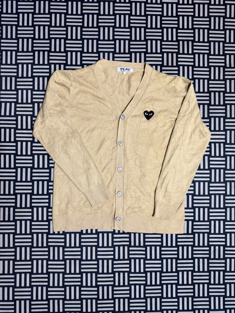 Play Comme des Garçons Beige Cardigan (Category: Coats, Jackets and Outerwear) located in Manila. Submitted by garcianath68674 (Listing ID 1469854043, Image 1). Description: - Brand: Play Comme des Garçons - Color: Beige - Style: V-neck cardigan with front button closure - Detail: Iconic embroidered black heart patch on the left chest - Fit: Ribbed cuffs and hem - Material: Cozy knit fabric, ideal for cooler weather layering - Condition: Excellen