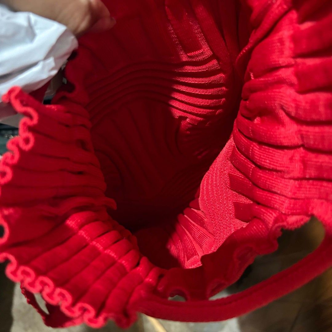 Pleats Mama Red Knitted Backpack (Category: Backpacks) located in Carmen. Submitted by ar_thrift00 (Listing ID 1469892903, Image 3). Description: - Brand: Pleats Mama - Style: Pleated knit backpack in a vibrant bright red - Design: Unique structural ribbed texture throughout with interior brand label - Closure: Drawstring opening at the top with matching shoulder straps - Features: Lightweight, easy to fold, and packable for travel - Condition: E