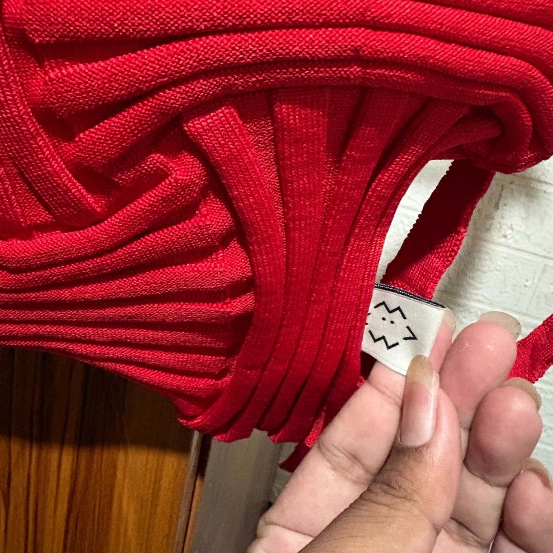 Pleats Mama Red Knitted Backpack (Category: Backpacks) located in Carmen. Submitted by ar_thrift00 (Listing ID 1469892903, Image 2). Description: - Brand: Pleats Mama - Style: Pleated knit backpack in a vibrant bright red - Design: Unique structural ribbed texture throughout with interior brand label - Closure: Drawstring opening at the top with matching shoulder straps - Features: Lightweight, easy to fold, and packable for travel - Condition: E