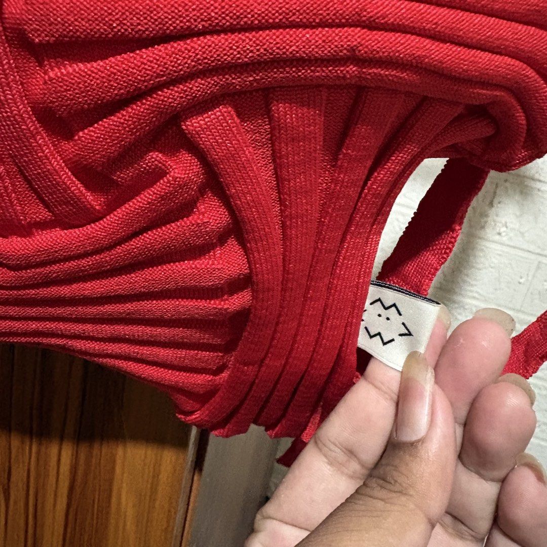PLEATS MAMA Red Knitted Pleated Backpack (Category: Backpacks) located in Carmen. Submitted by rr_thrifts (Listing ID 1469849828, Image 2). Description: - Brand: Pleats Mama - Color: Vibrant bright red - Material: Soft, high-quality knit fabric - Design: Unique all-over pleats with geometric panel details - Closure: Convenient top drawstring - Straps: Long, comfortable shoulder straps - Style: Standout statement piece, perfect for daily outfits -