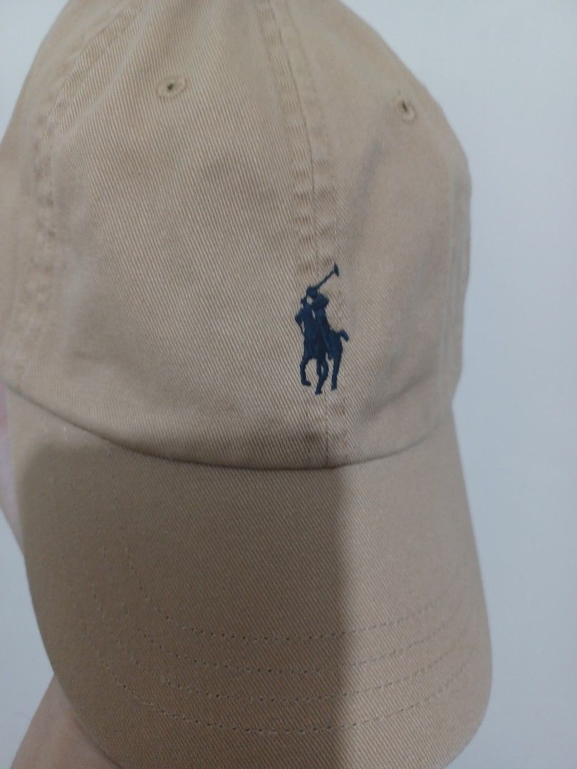 Polo Ralph Lauren Khaki Baseball Cap (Category: Caps & Hats) located in Mandaluyong City. Submitted by usamenfashionhaul (Listing ID 1469917794, Image 2). Description: - Brand: Polo Ralph Lauren - Color: Khaki beige with navy blue embroidered pony logo - Material: Comfortable cotton - Features: Breathable eyelets and embroidered POLO lettering on the back - Closure: Adjustable strap with metal buckle - Condition: Clean with minimal wear.