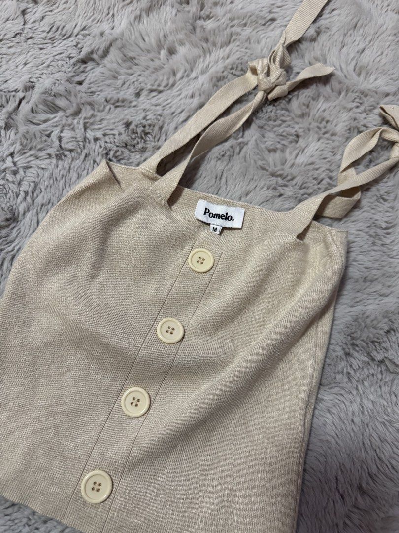 Pomelo Beige Knit Tank Top Size M (Category: Sleeveless) located in Calamba. Submitted by cheriiv (Listing ID 1469886393, Image 2). Description: - Brand: Pomelo - Style: Ribbed knit tank top - Color: Beige - Size: Medium (M) - Details: Adjustable tie-shoulder straps and front decorative buttons - Material: Soft and stretchy knit fabric.