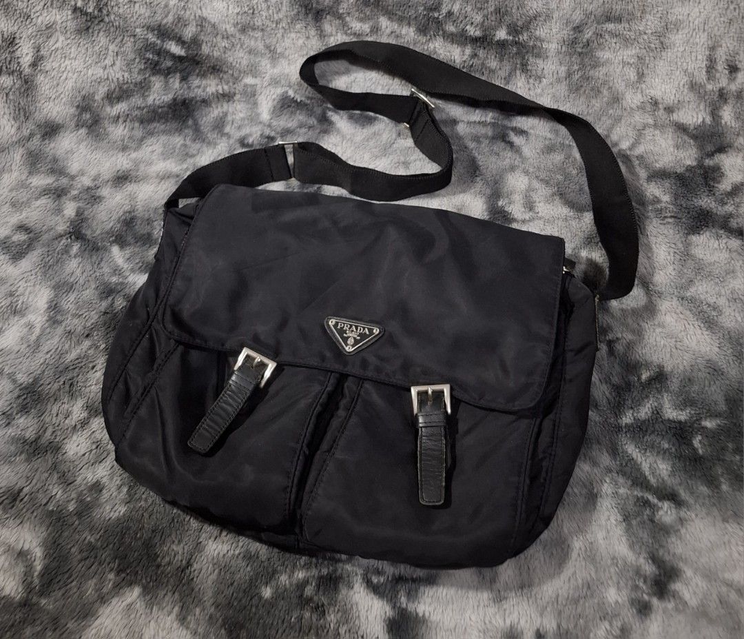Prada Black Nylon Messenger Bag with Front Pockets (Category: Luxury Bags & Wallets) located in Sorsogon. Submitted by johnmichae69459 (Listing ID 1469857417, Image 1). Description: - Prada black nylon messenger bag - Secure front flap with buckle straps and magnetic closure - Two spacious front pockets for easy organization - Adjustable shoulder strap with sleek silver hardware - Iconic Prada triangle logo badge on the front flap - Durable fabri
