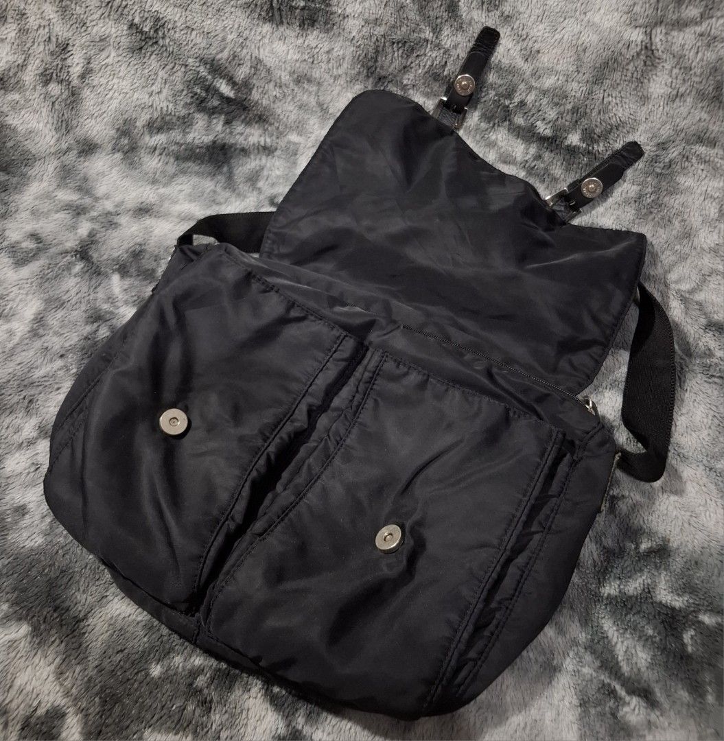 Prada Black Nylon Messenger Bag with Front Pockets (Category: Luxury Bags & Wallets) located in Sorsogon. Submitted by johnmichae69459 (Listing ID 1469857417, Image 3). Description: - Prada black nylon messenger bag - Secure front flap with buckle straps and magnetic closure - Two spacious front pockets for easy organization - Adjustable shoulder strap with sleek silver hardware - Iconic Prada triangle logo badge on the front flap - Durable fabri