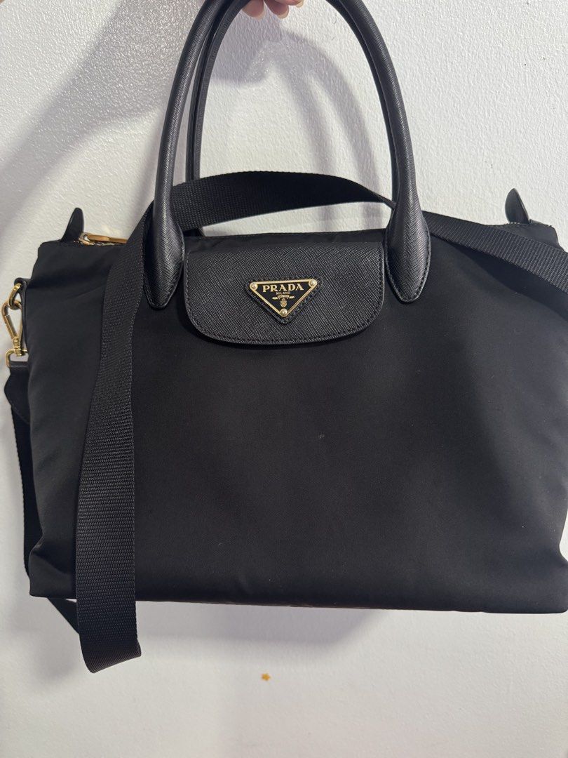 Prada Black Nylon Tote Shoulder Bag (Category: Luxury Bags & Wallets) located in Manila. Submitted by decluterthings888 (Listing ID 1469834588, Image 1). Description: - Brand: Prada - Material: Durable black nylon with Saffiano leather trim - Hardware: Elegant gold-tone accents - Straps: Double top handles and an adjustable fabric shoulder strap - Exterior: Front flap pocket featuring the iconic triangular logo plaque - Closure: Secure top zipper