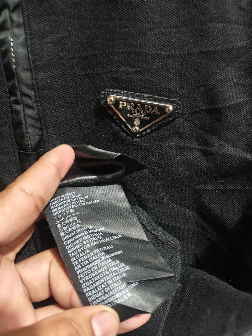 Prada Black Zip-Up Polo Shirt (Category: Tshirts & Polo Shirts ) located in Manila. Submitted by joshespino71762 (Listing ID 1469944130, Image 3). Description: - Black Prada short-sleeve polo shirt - Half-zip front closure with premium silver-tone hardware - Iconic Prada enamel triangle logo on the left chest - Crafted from comfortable, classic knit fabric with a ribbed collar - Includes Prada Milano woven neck label and inner wash tags - Made in