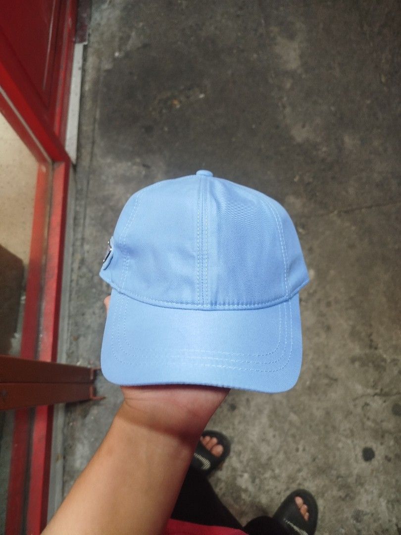 Prada Light Blue Nylon Baseball Cap (Category: Caps & Hats) located in Manila. Submitted by alenoid (Listing ID 1469802521, Image 1). Description: - Authentic Prada baseball cap in a stylish light blue shade - Brand new with tags (BNWT) attached - Material: 100% durable nylon with 100% comfortable cotton lining - Features the iconic enameled metal triangle Prada Milano logo on the side - Adjustable back strap for a customized fit - Perfect for ev