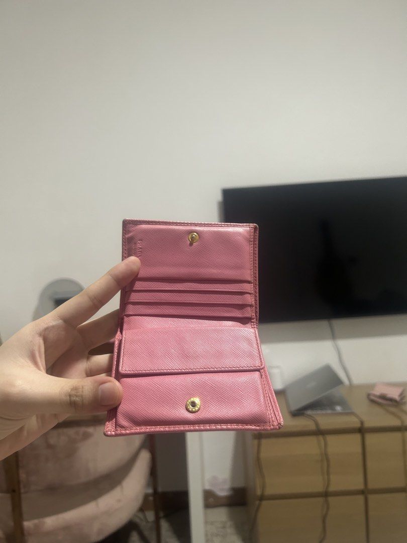Prada Pink Saffiano Leather Compact Wallet (Category: Luxury Bags & Wallets) located in Quezon City. Submitted by bubblegummmmmmmmmmmmm (Listing ID 1469854274, Image 2). Description: - Authentic Prada Saffiano leather wallet in a chic pink shade - Elegant gold-tone hardware with iconic metal lettering logo - Secure snap button closure - Interior includes multiple card slots, bill compartment, and snap coin pocket - Compact and lightweight, perfec