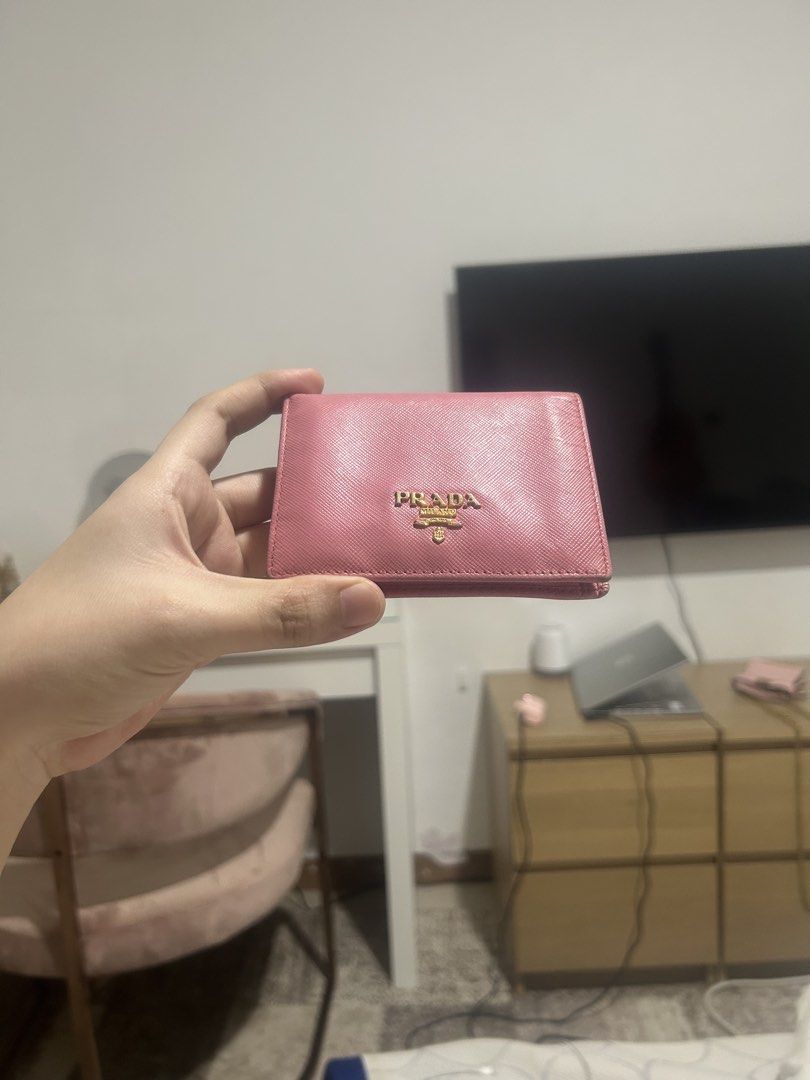 Prada Pink Saffiano Leather Compact Wallet (Category: Luxury Bags & Wallets) located in Quezon City. Submitted by bubblegummmmmmmmmmmmm (Listing ID 1469854274, Image 1). Description: - Authentic Prada Saffiano leather wallet in a chic pink shade - Elegant gold-tone hardware with iconic metal lettering logo - Secure snap button closure - Interior includes multiple card slots, bill compartment, and snap coin pocket - Compact and lightweight, perfec