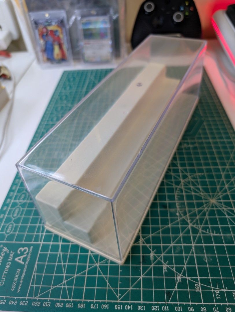 [Pre-Loved] 30cm Tiered Acrylic Display Case – Clear & Dustproof (Category: Storage Boxes & Baskets) located in Manila. Submitted by echollect (Listing ID 1469858270, Image 2). Description: Clearing space! ₱175 each 3 pcs available. I'm Selling a pre-owned 30x9x10 cm Clear Acrylic Display Case with a white tiered riser base. ​Material: Clear Acrylic + Plastic Base ​Dimensions: 30 cm (L) x 9 cm (W) x 10 cm (H) ​Condition: Pre-owned (has super mino