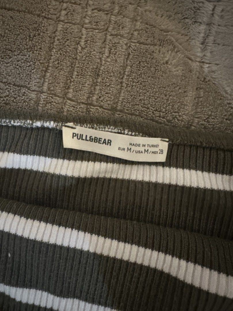 Pull&Bear Striped Ribbed Tube Top (Category: Sleeveless) located in Manila. Submitted by cabuniagpr58494 (Listing ID 1469872338, Image 2). Description: - Brand: Pull&Bear - Style: Olive green and white striped tube top - Size: M - Material: Stretchy ribbed fabric - Origin: Made in Turkey - Condition: Clean with tags intact - Perfect for layering or warm days.