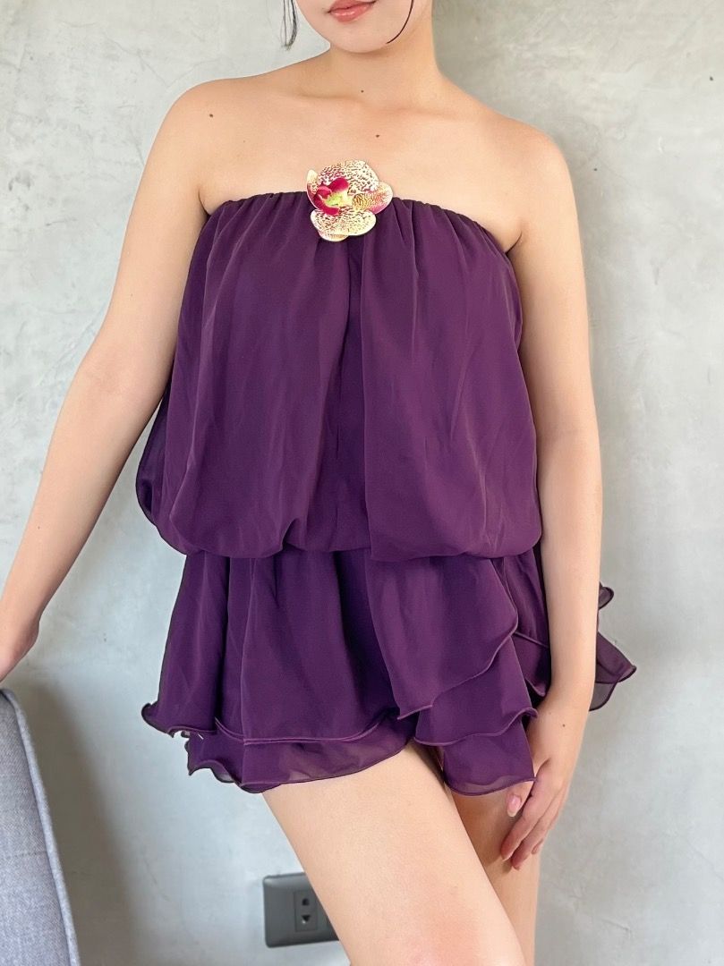 Purple strapless floral accent bubble romper playsuit (Category: Rompers) located in Caloocan City. Submitted by zaviscool (Listing ID 1469783453, Image 1). Description: - Deep purple strapless bubble romper in lightweight, flowy chiffon - Layered ruffle shorts section for a playful, voluminous look - Includes a detachable yellow and red orchid flower brooch at the neckline - Easy pull-on style featuring a secure and comfortable elasticated top -