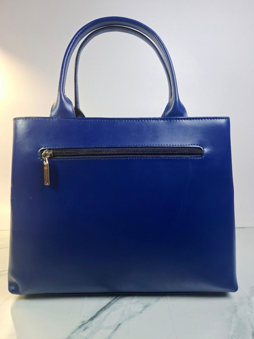 Ra Iride Blue Leather Tote Handbag (Category: Tote Bags) located in Pasay City. Submitted by onick_79 (Listing ID 1469928279, Image 2). Description: - Dimensions: L 30 x H 24 x W 7.5 cm - Brand: Ra Iride - Color: Vibrant blue - Material: Premium leather - Features: Double top handles and exterior zip pocket with branded hardware pull - Protection: Metal feet on the bottom for extra durability - Design: Clean lines, classic shape, and solid struct