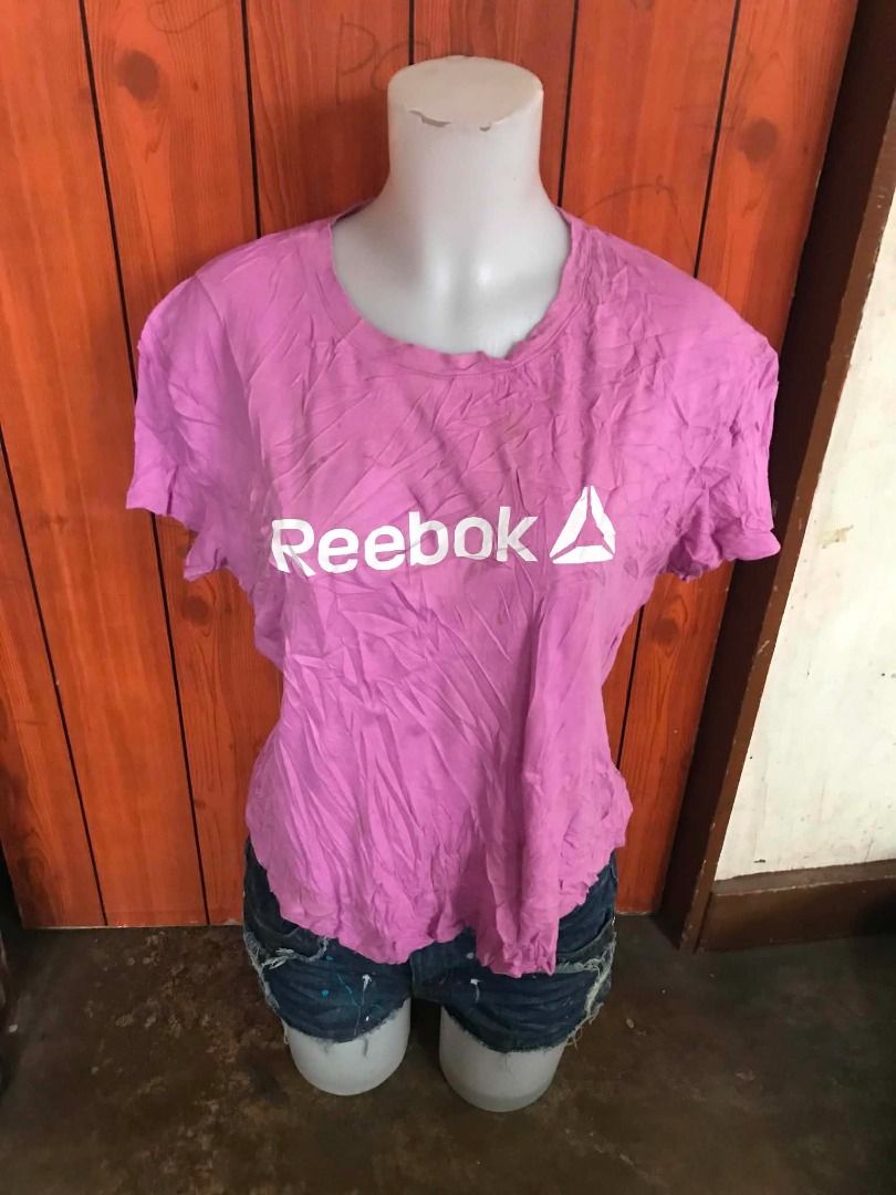 Reebok Pink T-Shirt with Logo (Category: Shirts) located in San Jose. Submitted by lerwomensthrift (Listing ID 1469909235, Image 1). Description: - Brand: Reebok - Color: Pink with large white logo on chest - Style: Casual athletic, short sleeves, crew neckline - Fit: Easy to pair with denim shorts or jeans - Condition: Good, with minor wrinkles from storage.