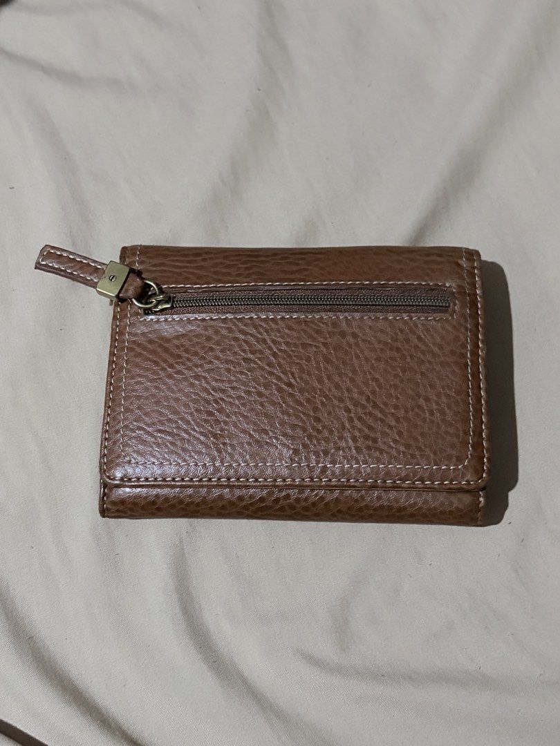 Relic Brown Leather Trifold Wallet (Category: Wallets & Card holders) located in Quezon City. Submitted by angelajuliet__ (Listing ID 1469921065, Image 2). Description: - Brand: Relic - Material: Brown pebbled leather with white contrast stitching - Closure: Secure snap button - Exterior: Handy zip pocket for coins or small items - Interior: Multiple card slots, ID window, and cash compartments - Condition: Clean inside and out, well-maintained -