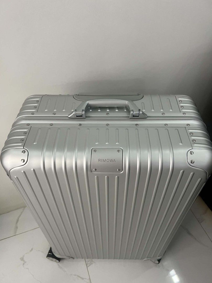 Rimowa Aluminium Suitcase Silver Check in (Category: Luggage) located in Paoay. Submitted by rvf1230 (Listing ID 1469810634, Image 3). Description: - Brand: Rimowa - Material: Premium silver aluminium with iconic grooved design - Condition: Excellent, clean exterior with no major scratches or dents - Mobility: Smooth multi-wheel system and adjustable telescopic handle - Hardware: Sturdy metal hinges, corner guards, and clearly engraved logo badge