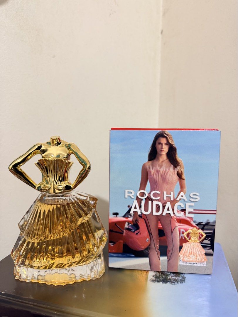 Rochas Audace Eau de Parfum 90ml (Category: Fragrance & Deodorants) located in Cavite. Submitted by mgd.blessed (Listing ID 1469912397, Image 3). Description: - Brand: Rochas Audace - Type: Eau de Parfum (EDP) - Size: 90ml - Packaging: Includes original red box - Design: Iconic golden dress-shaped bottle - Origin: Made in France - Format: Standard spray - Condition: Brand new / Excellent -gift from SG.