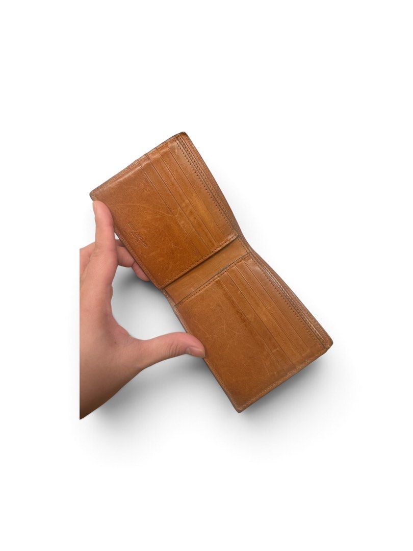Saint Laurent Paris Brown Leather Bifold Wallet (Category: Wallets & Card holders) located in Manila. Submitted by attypreciousyzncpa (Listing ID 1466150185, Image 2). Description: - Authentic Saint Laurent Paris bifold wallet - Crafted from rich brown leather with a natural patina from regular use - Iconic gold-foil logo stamped on the front - Pocket-friendly, classic everyday size - Clean and durable stitching along all edges.