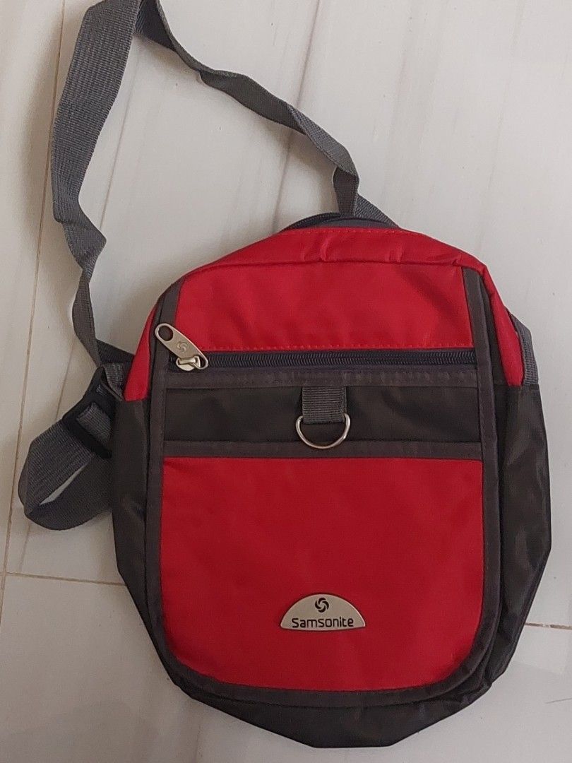 Samsonite Red and Grey Sling Bag (Category: Sling Bags) located in Malaybalay. Submitted by mags_sofia (Listing ID 1469873041, Image 1). Description: - Adjustable shoulder strap for a custom fit - Front zippered pocket with metal D-ring attachment and a wide-opening main compartment - Clean grey interior lining - Ideal for daily essentials, commuting, or travel.