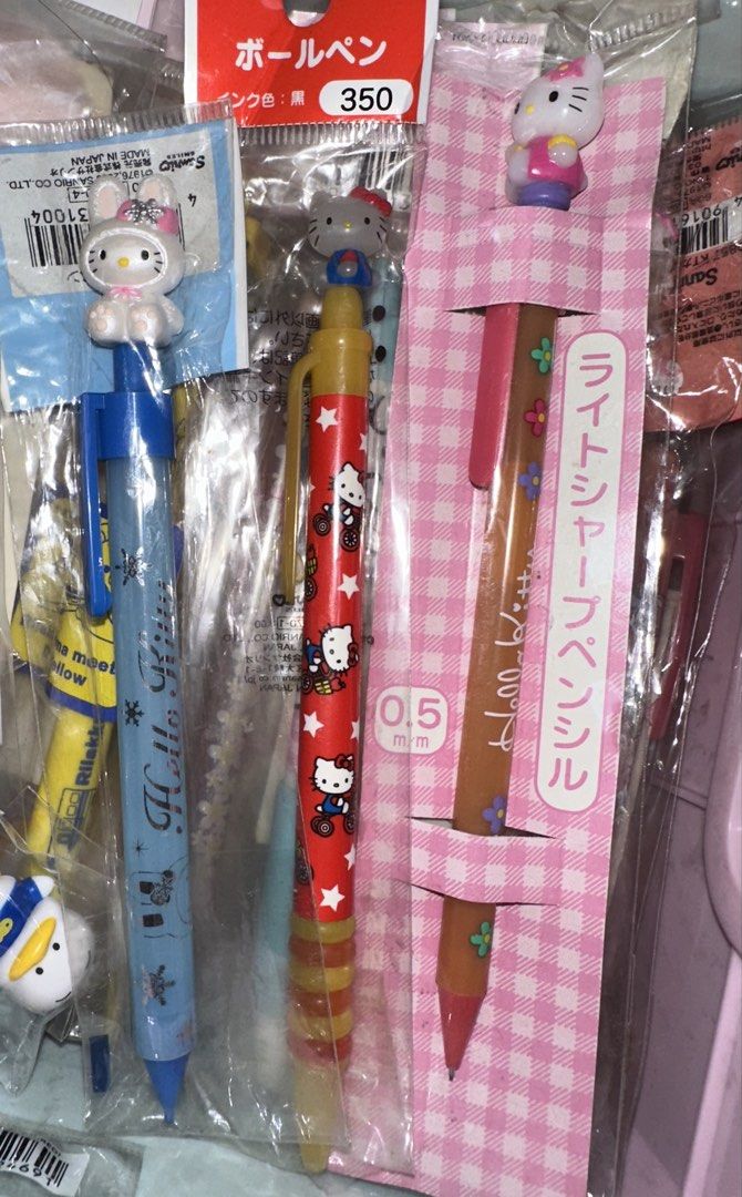 Sanrio Hello Kitty Mechanical Pen and Ballpoint Pen Set (Category: Stationery & School Supplies) located in Quezon City. Submitted by mitchapple88 (Listing ID 1469835339, Image 1). Description: Three Sanrio Kitty pens in original packaging. Includes a blue pen with bunny cap topper, a red patterned pen with a grey Kitty figure, and a pink checkered mechanical pencil with a small 0.5mm lead size and top character topper. Japanese text on packaging