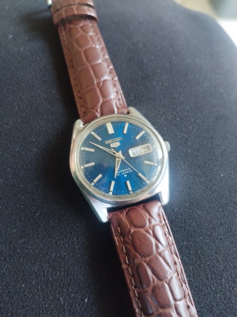 Seiko 5 Automatic 21 Jewels Blue Dial Watch (Category: Men's Watches) located in Pasig City. Submitted by BeatsandTicks (Listing ID 1469828257, Image 2). Description: - Model: Seiko 5 Automatic Watch - Dial: Striking blue with silver hands and hour markers - Features: Convenient day-date window at 3 o'clock - Movement: Reliable 21 jewels automatic movement - Strap: Classic silver-tone case paired with a brown embossed leather strap - Condition: G