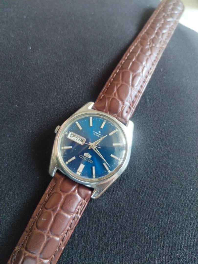 Seiko 5 Automatic 21 Jewels Blue Dial Watch (Category: Men's Watches) located in Pasig City. Submitted by BeatsandTicks (Listing ID 1469828257, Image 3). Description: - Model: Seiko 5 Automatic Watch - Dial: Striking blue with silver hands and hour markers - Features: Convenient day-date window at 3 o'clock - Movement: Reliable 21 jewels automatic movement - Strap: Classic silver-tone case paired with a brown embossed leather strap - Condition: G