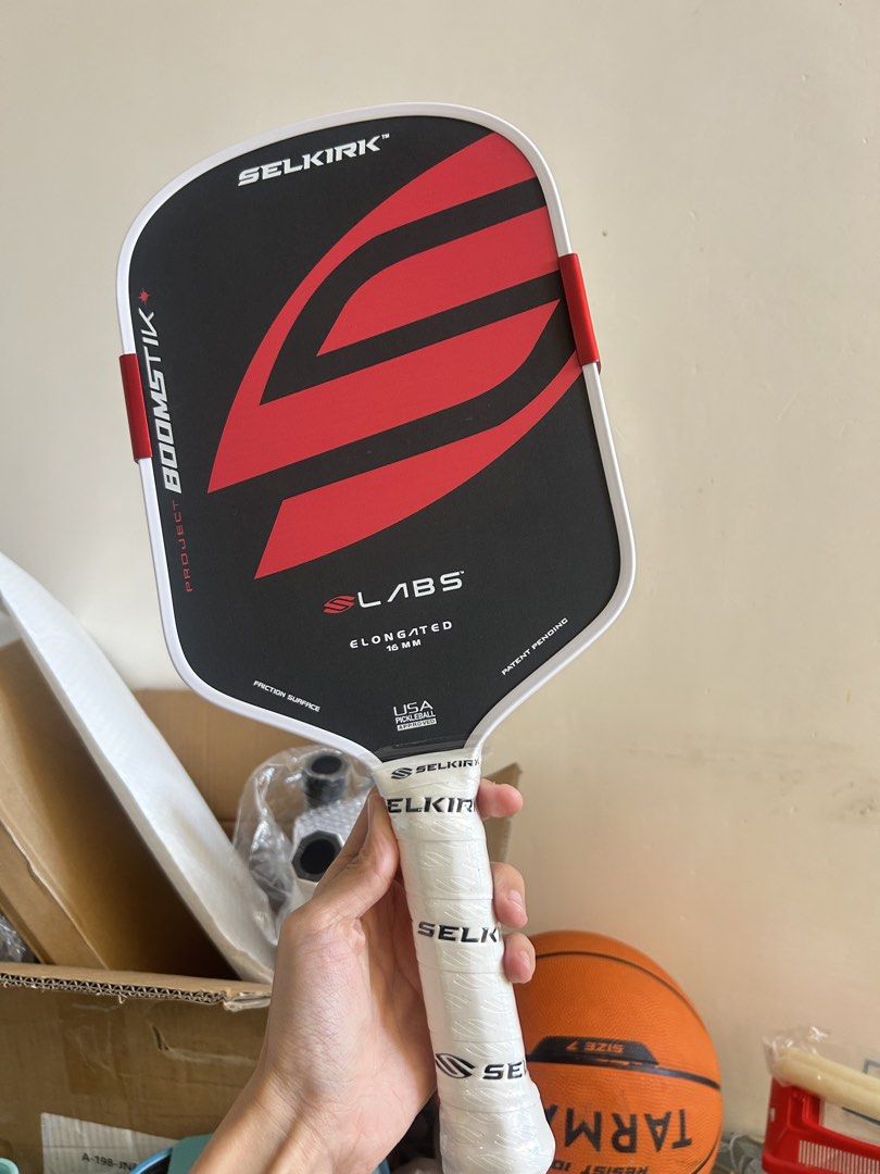 Selkirk Boomstik Pickleball Paddle (Category: Racket and Ball Sports) located in Cavite. Submitted by _schmyla (Listing ID 1469888379, Image 2). Description: - Model: Selkirk Labs Project 003 Boomstik - Shape & Core: Elongated shape with 16 mm thickness - Design: Striking red and black graphics with a clean white edge guard - Enhancements: Custom edge weights attached on both sides for extra power - Grip: Securely wrapped white grip tape on the h